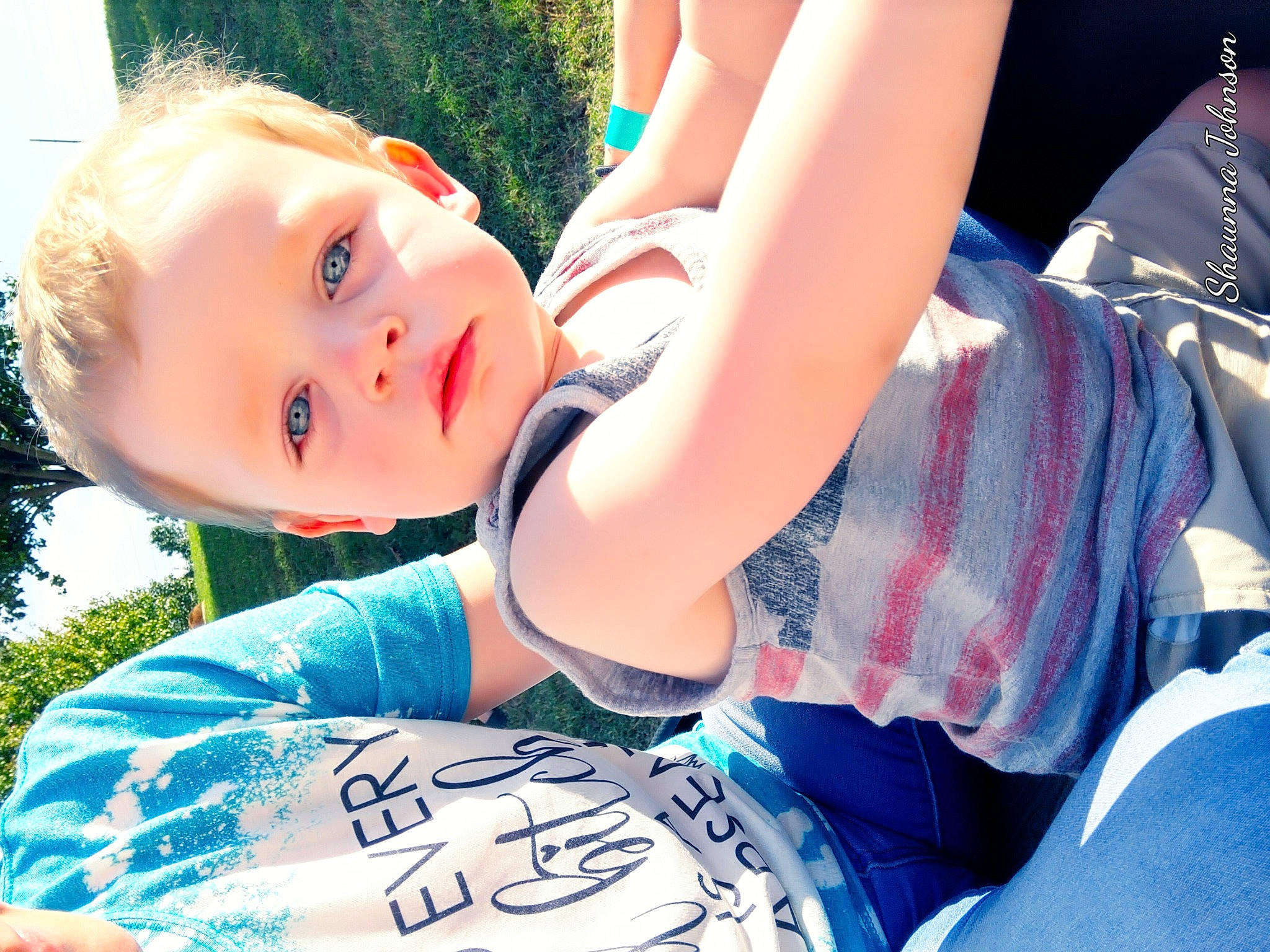 Dezmond is registered to the contest to win money with this photo: arm, azure, child, cool, electric_blue, flash_photography, fun, gesture, grass, happy, leisure, people_in_nature, person, plant, recreation, sitting, summer, sunlight, t_shirt, toddler