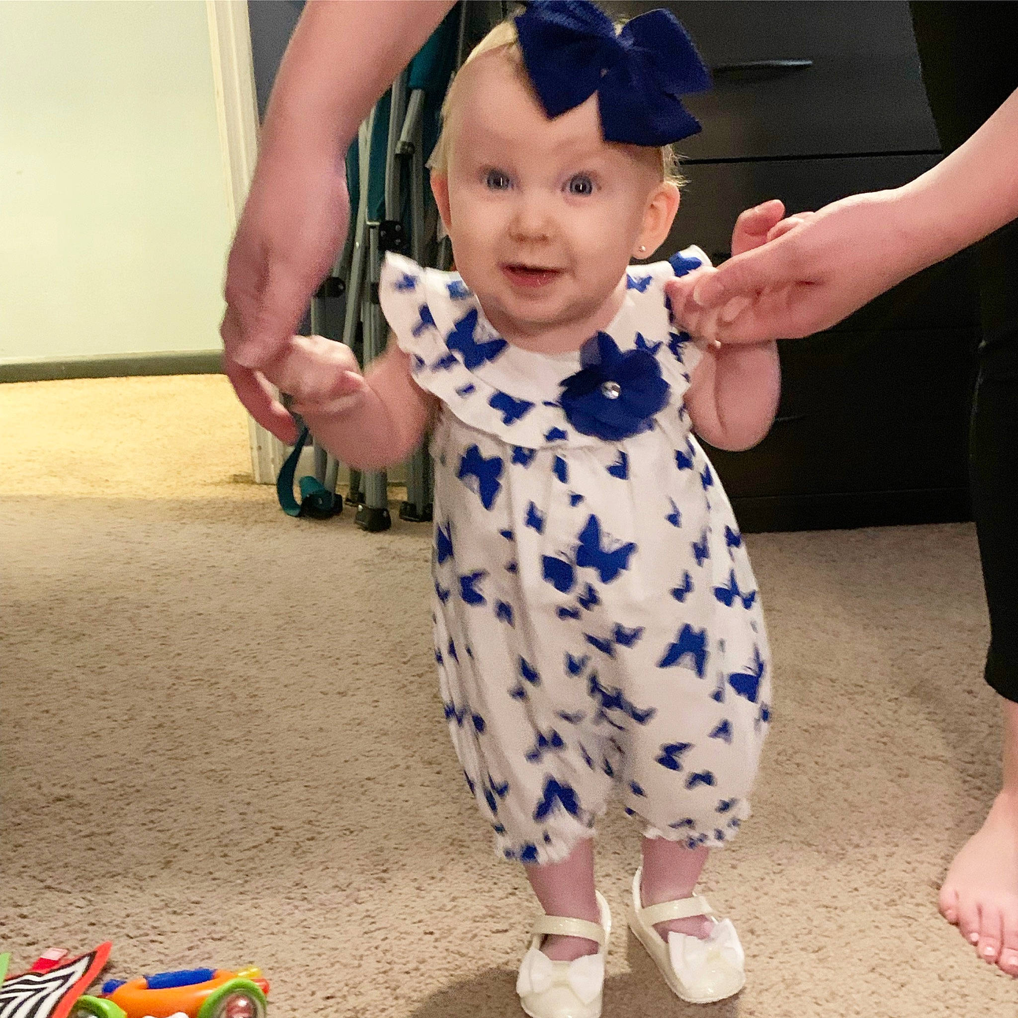 Kora is registered to the contest to win money with this photo: arm, baby, baby_toddler_clothing, blue, child, finger, fun, gesture, hairstyle, happy, joint, joy, one_piece_garment, person, skin, sleeve, smile, standing, textile, thumb