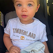 Ghjuvan-Andria participe au concours pour gagner de l'argent avec cette photo : toddler, child, car_seat, blanket, plush_toy, blue_eyes, timberland_tshirt, casual_clothing, indoor, portrait, baby, cute, hands, soft_toys, comfort, seated, expression, close_up, natural_light, young_child