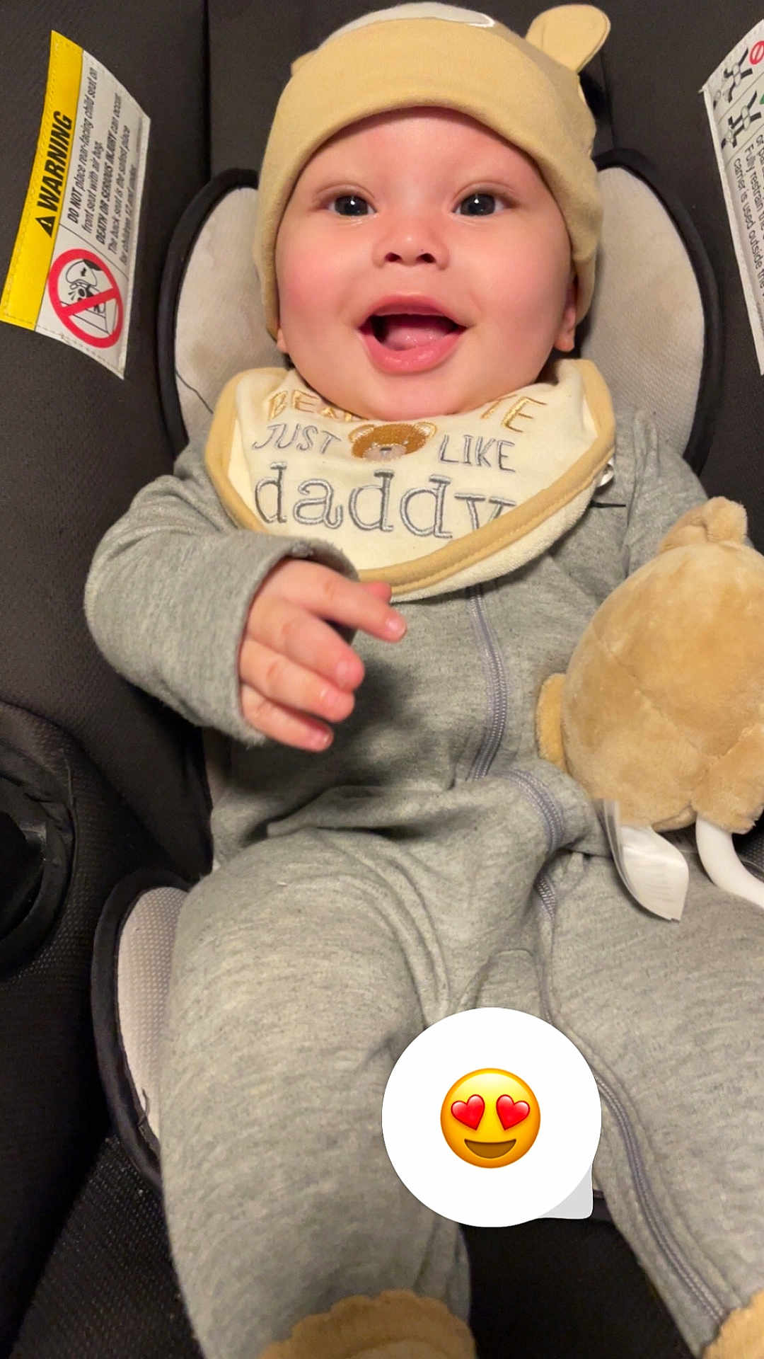 Tyree is registered to the contest to win money with this photo: baby, smiling, child, pajamas, hat, bib, plush_toy, car_seat, happy, cute, infant, face, hand, clothing, indoors, seat, expression, comfort, adorable, portrait