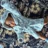 baby, infant, child, robe, hooded_clothing, blanket, floral_pattern, socks, lying_down, cute, playful, indoor, soft_texture, curious, small_hands, small_feet, portrait, cozy, comfortable, fabric