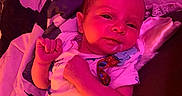 Jensen is registered to the contest to win money with this photo: baby, infant, lying_down, blanket, onesie, face, drool, colorful, patterned_blanket, pink_light, purple_light, cute, young_child, indoors, sleeping_area, relaxed, portrait, small_hands, pacifier_clip, soft_fabric
