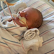 Jensen is registered to the contest to win money with this photo: newborn, baby, hospital, blanket, medical_tube, swaddled, infant, bed, healthcare, resting, patient, face, sleeping, wrapped, towel, closeup, person, care, medical, cute