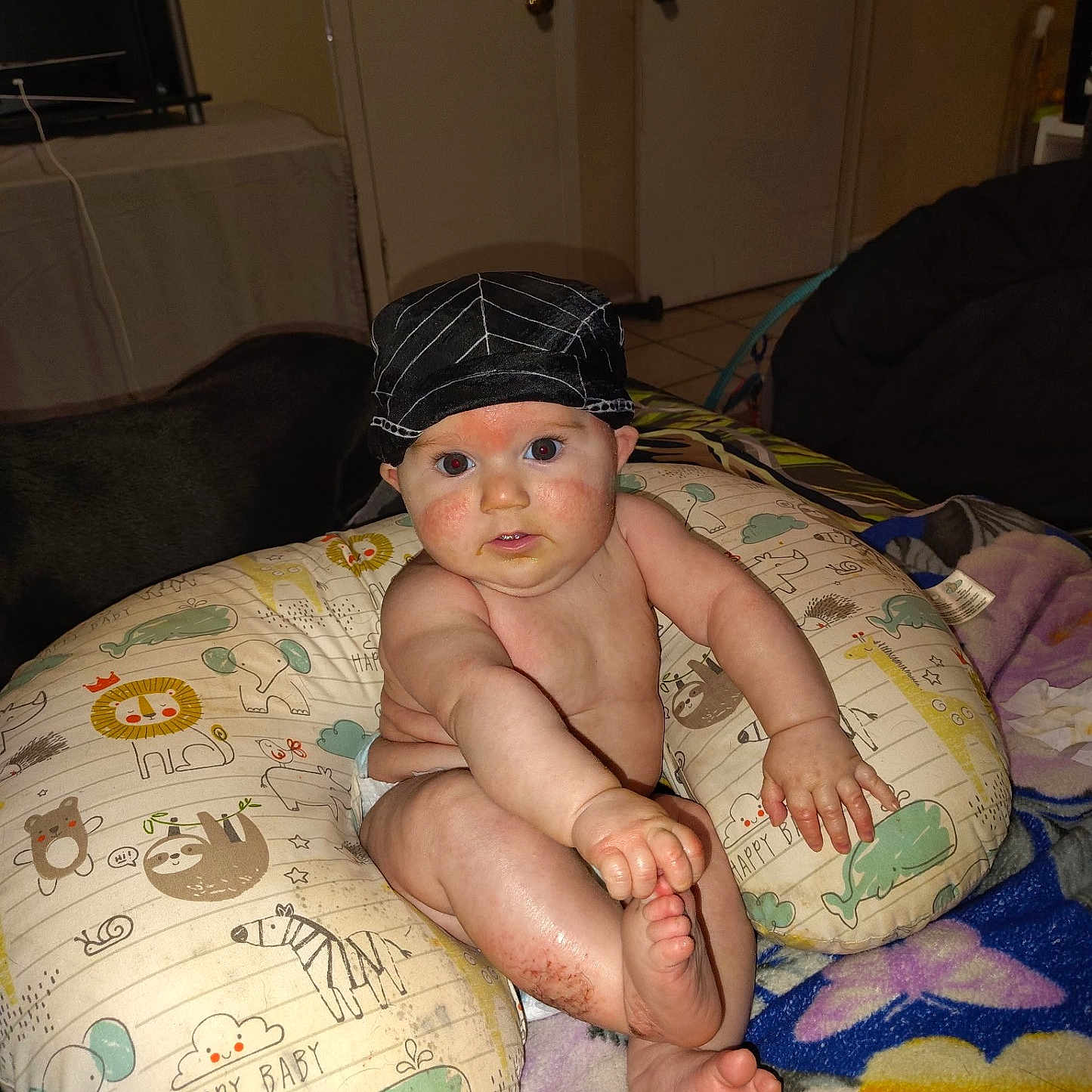 Allen joined the competition — help win amazing prizes! animal_print, baby, blanket, child, childhood, comfort, curious, cute, diaper, expression, face, foot, hand, hat, home, indoor, infant, pillow, sitting, skin