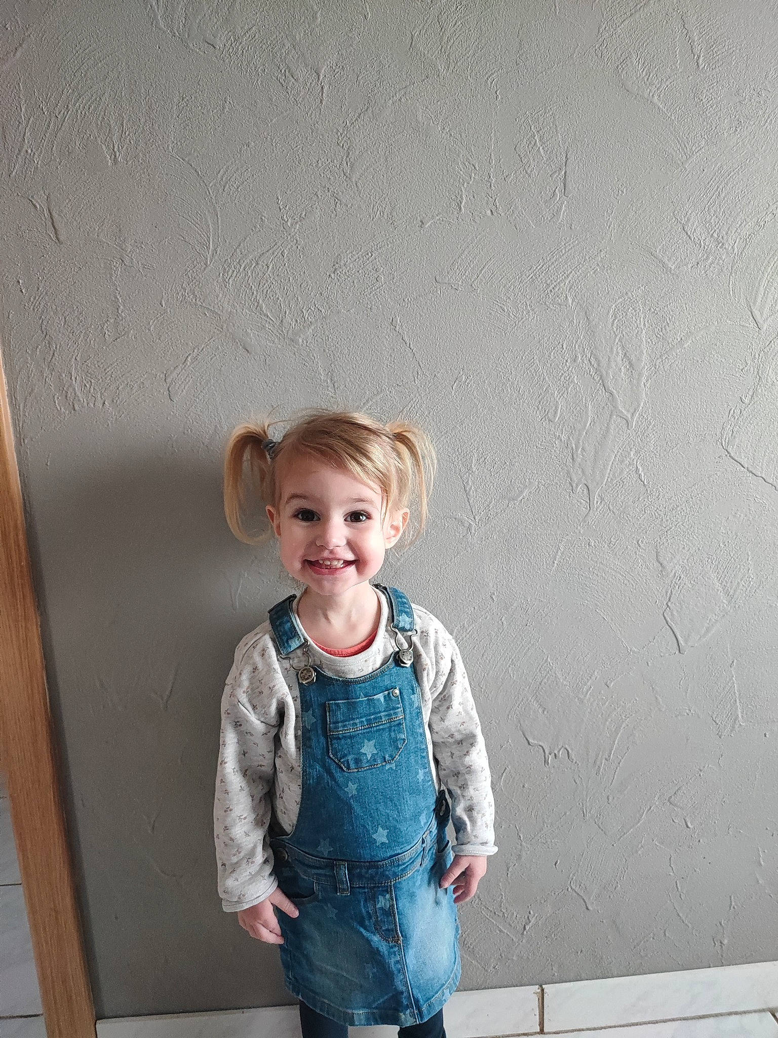 Héloïse participe au concours pour gagner de l'argent avec cette photo : baby_toddler_clothing, blond, child, denim, electric_blue, fashion_design, flash_photography, fun, happy, joy, pattern, person, portrait_photography, room, shoulder, sleeve, smile, standing, t_shirt, toddler