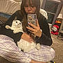 Chessie is registered to the contest to win money with this photo: person, cat, mirror_selfie, smartphone, phone_case, pajamas, plaid_pants, carpet, bedroom, bed, lamp, window, curtains, stuffed_toy, reflection, long_hair, nail_polish, pet, sitting, cozy