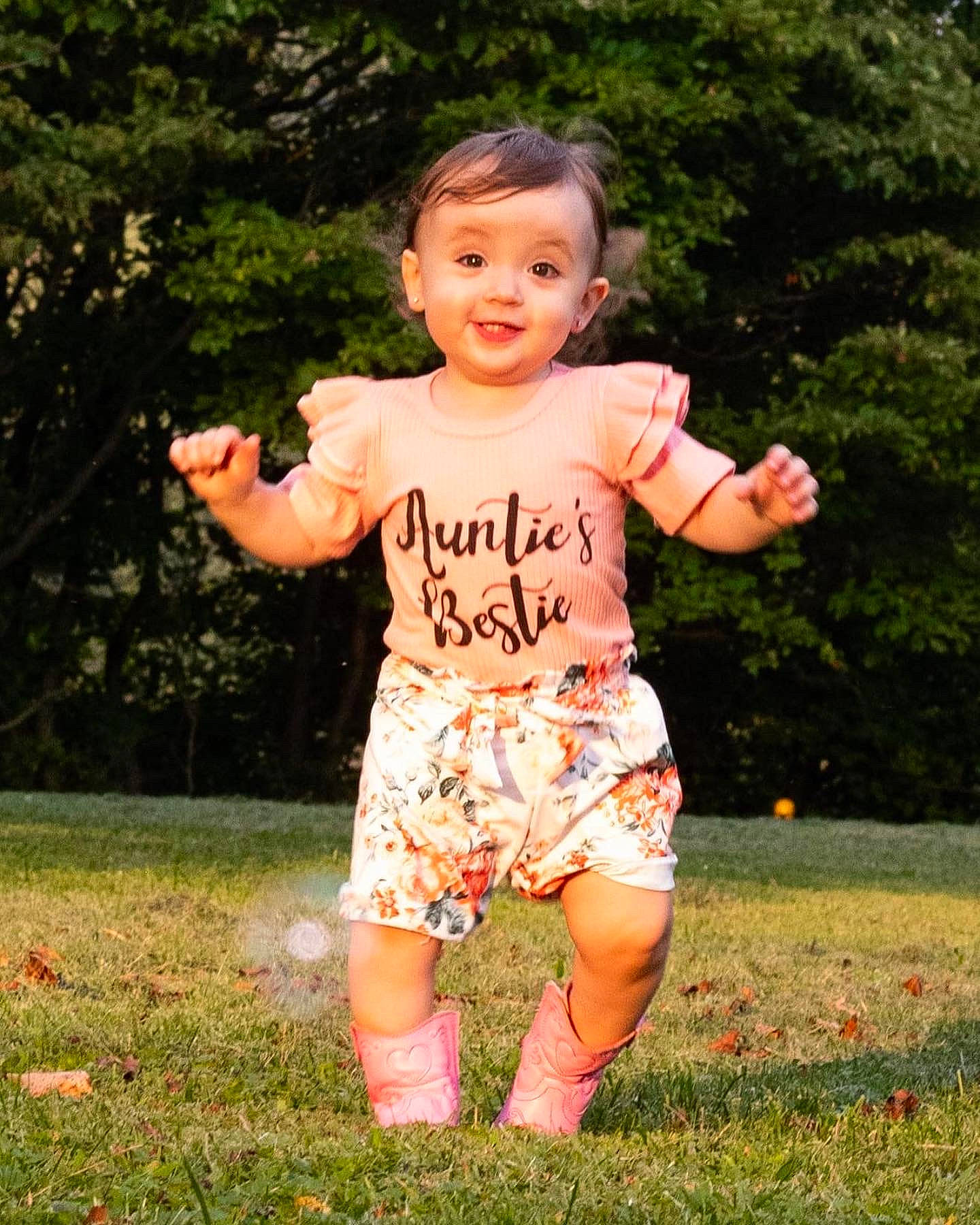 Ellie joined the competition — help win amazing prizes! baby_toddler_clothing, barefoot, face, finger, fun, gesture, grass, happy, head, joy, lawn, leisure, people_in_nature, person, plant, recreation, shorts, sleeve, smile, t_shirt