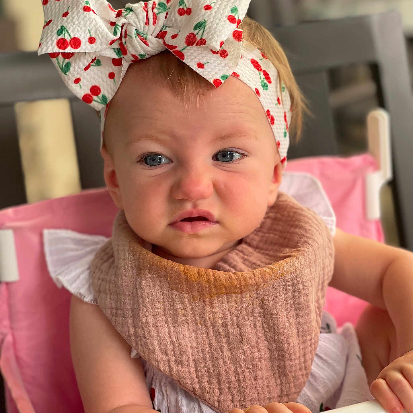 Elizabeth joined the competition — help win amazing prizes! baby, infant, child, portrait, face, serious_expression, headband, bow, cherry_pattern, bib, high_chair, pink, indoor, sitting, tray, hands, eyes, blonde_hair, home, photography
