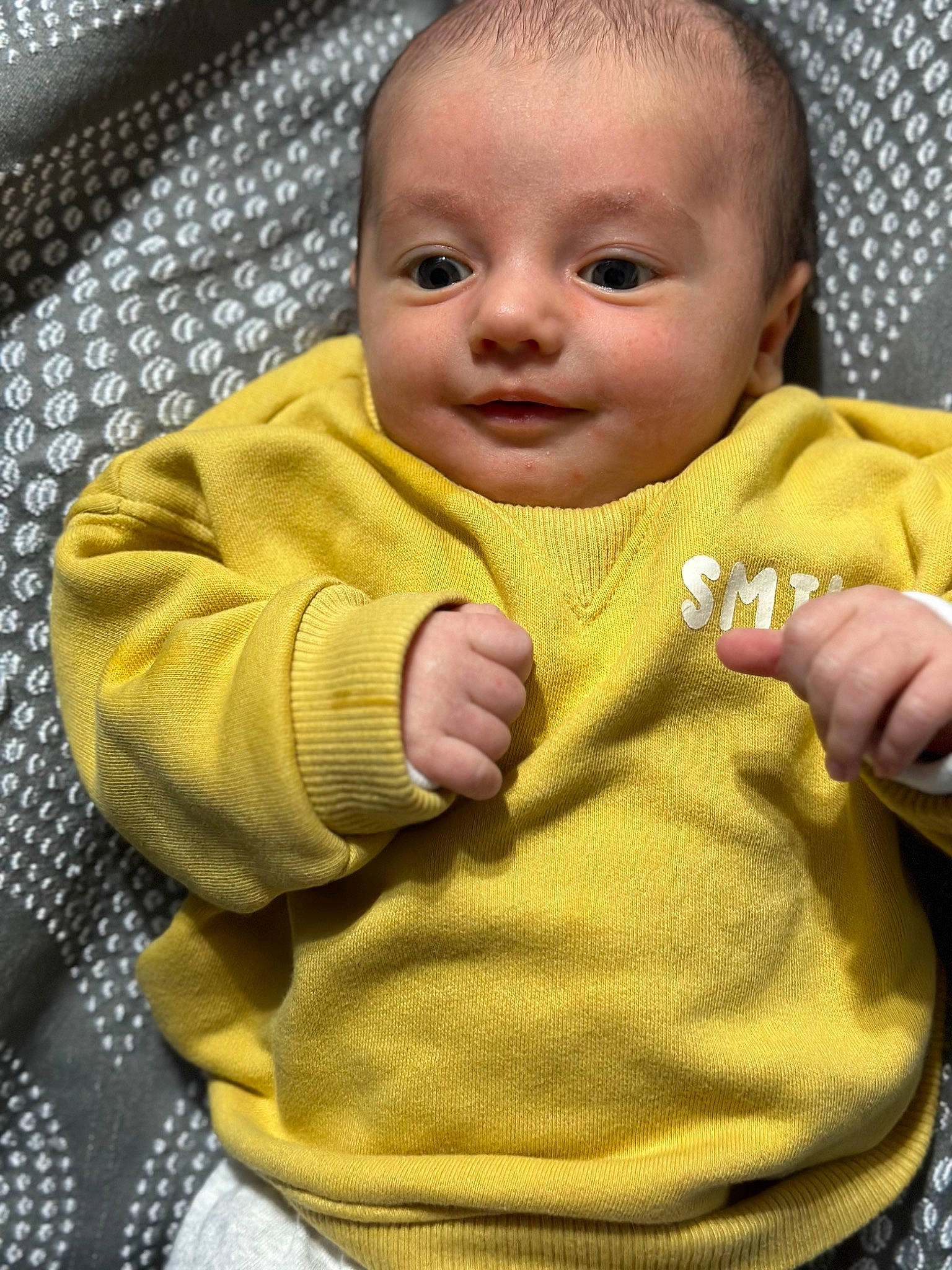 Jupiter is registered to the contest to win money with this photo: baby, baby_toddler_clothing, cheek, child, comfort, eyebrow, face, facial_expression, finger, gesture, hand, happy, head, lip, nose, person, product, skin, sleeve, thumb