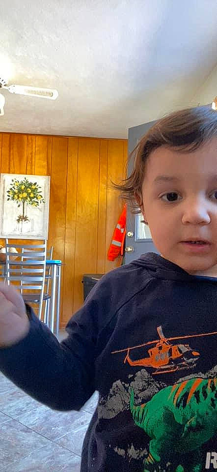 Jonah is registered to the contest to win money with this photo: ceiling, chair, child, curtain, fun, gesture, happy, holiday, person, plant, room, sitting, sleeve, standing, t_shirt, toddler, top, tree, wood