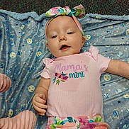Azlyn is registered to the contest to win money with this photo: baby, infant, headband, pink_shirt, floral_pants, blanket, patterned_blanket, lying_down, cute, child, smiling, happy, indoor, portrait, person, clothing, colorful, small_child, baby_girl, soft_texture