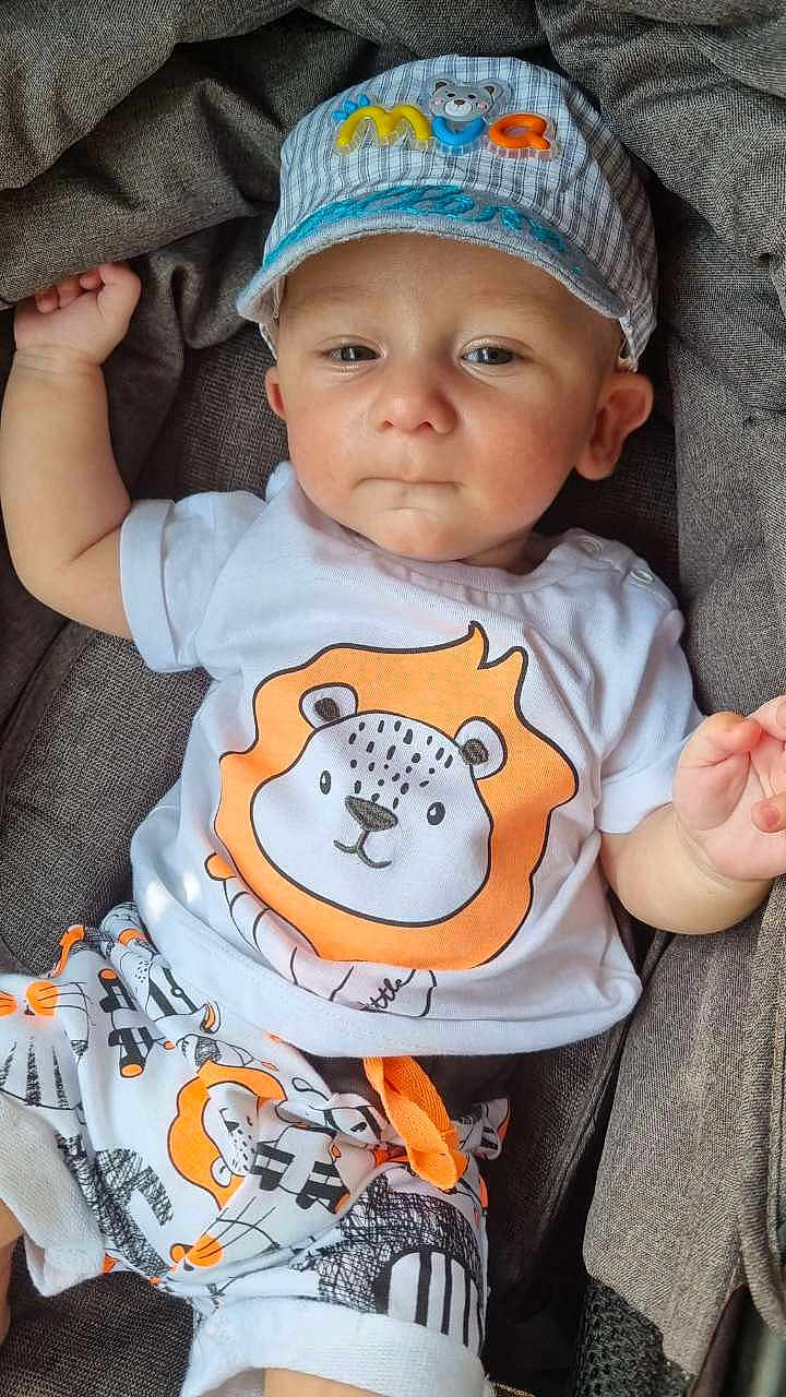 Willem a rejoint le concours — aidez-le/la à gagner de superbes lots ! baby, child, cap, hat, clothing, lion_print, tshirt, shorts, patterned_clothing, fabric, gray_background, infant, cute, casual, portrait, young_child, sitting, comfortable, indoor, soft