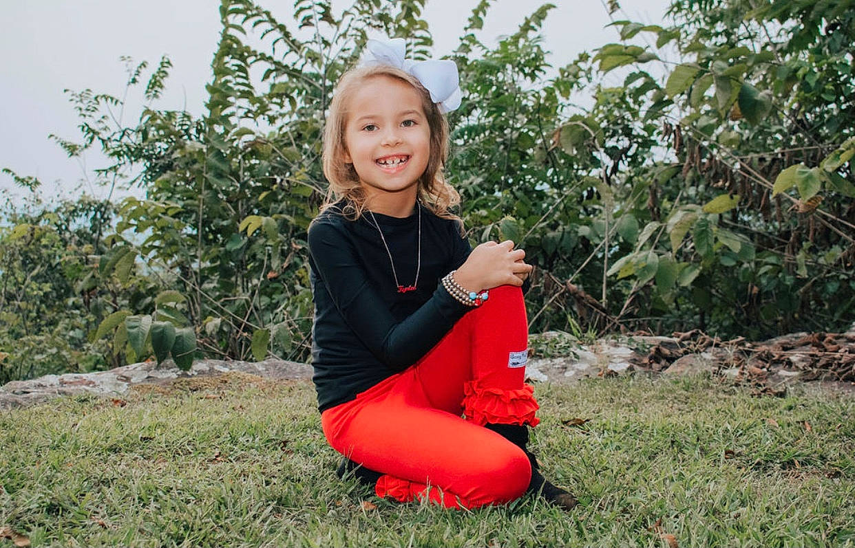 Kynlee is registered to the contest to win money with this photo: blond, child, child_model, dress, footwear, grass, happy, joy, leg, person, photo_shoot, photography, plant, red, shoe, sitting, smile, sportswear, style, summer