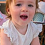 toddler, child, smiling, white_dress, outdoor, portrait, happy, face, cute, young_child, person, embroidery, candid, daylight, expression, eyes, hair, skin, restaurant, chair