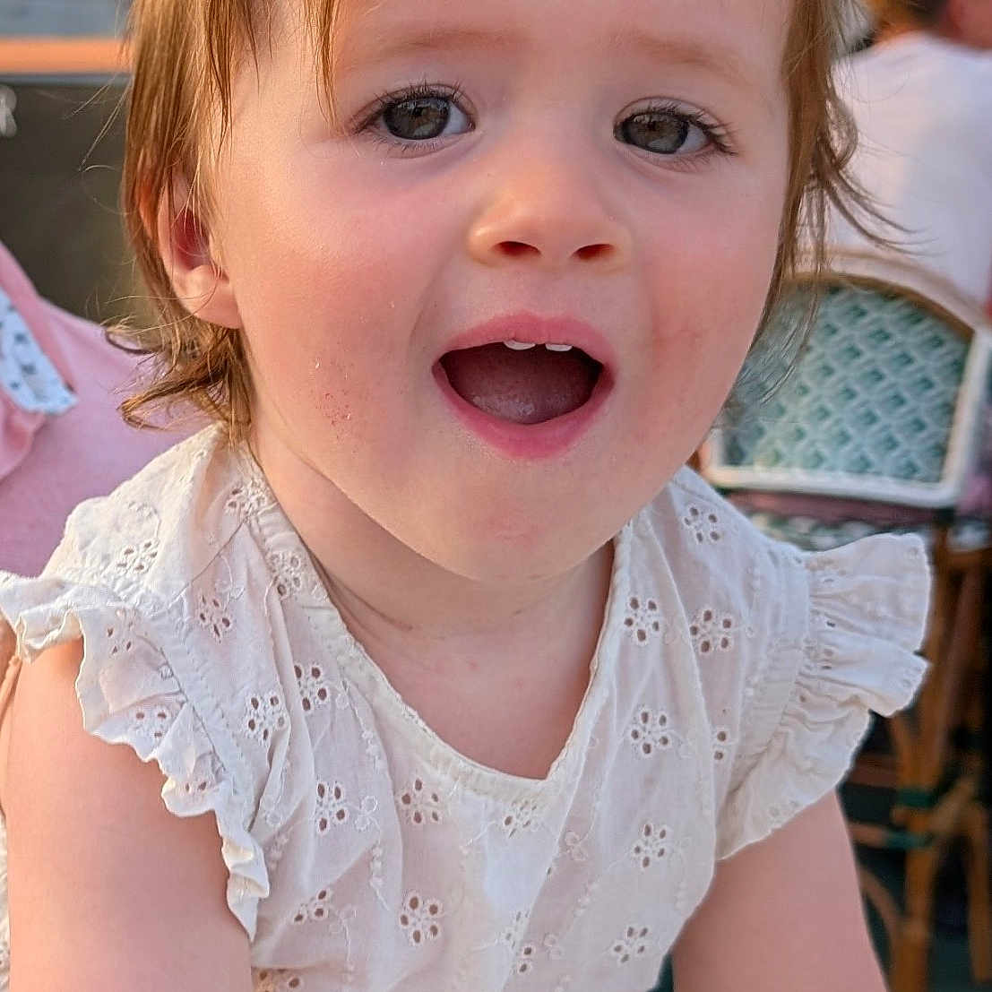 Sharlie a rejoint le concours — aidez-le/la à gagner de superbes lots ! candid, chair, child, cute, daylight, embroidery, expression, eyes, face, hair, happy, outdoor, person, portrait, restaurant, skin, smiling, toddler, white_dress, young_child