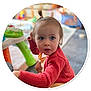 Sharlie a rejoint le concours — aidez-le/la à gagner de superbes lots ! toddler, child, portrait, indoor, red_sweater, blue_eyes, curly_hair, playroom, toy, face, person, young_child, cute, sitting, casual_clothing, expression, looking_away, skin, hair, small_hands