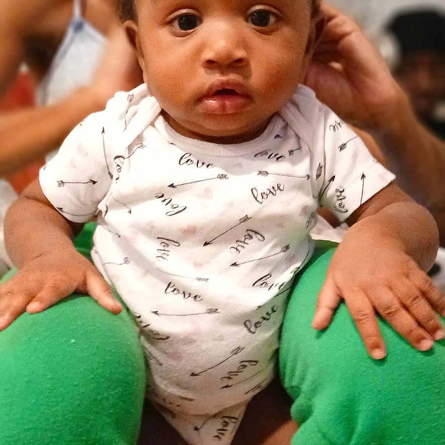 Journey joined the competition — help win amazing prizes! baby, background, blurred, child, cozy, curious, cute, expression, face, green_pants, hair_bows, hands, indoor, infant, legs, person, sitting, skin, white_onesie, wide_eyes