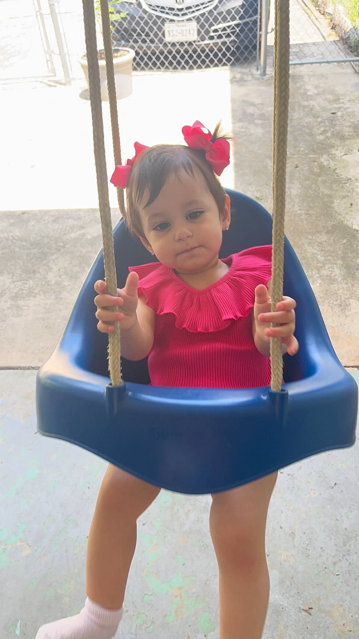 Aryana is registered to the contest to win money with this photo: baby, baby_toddler_clothing, child, city, electric_blue, facial_expression, foot, fun, happy, human_leg, knee, leisure, magenta, outdoor_play_equipment, person, pink, recreation, sitting, swing, thigh