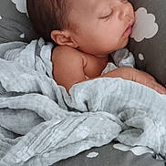 Luna is registered to the contest to win money with this photo: baby, sleeping, blanket, cushion, cloud_pattern, infant, resting, soft_texture, peaceful, child, wrapped, cozy, indoors, portrait, head, face, newborn, relaxing, cute, toddler