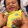 Leo joined the competition — help win amazing prizes! baby, child, smiling, laughing, curly_hair, yellow_clothing, blanket, hand, tattoo, playful, tongue_out, happy, indoor, infant, cute, person, portrait, closeup, joyful, expression
