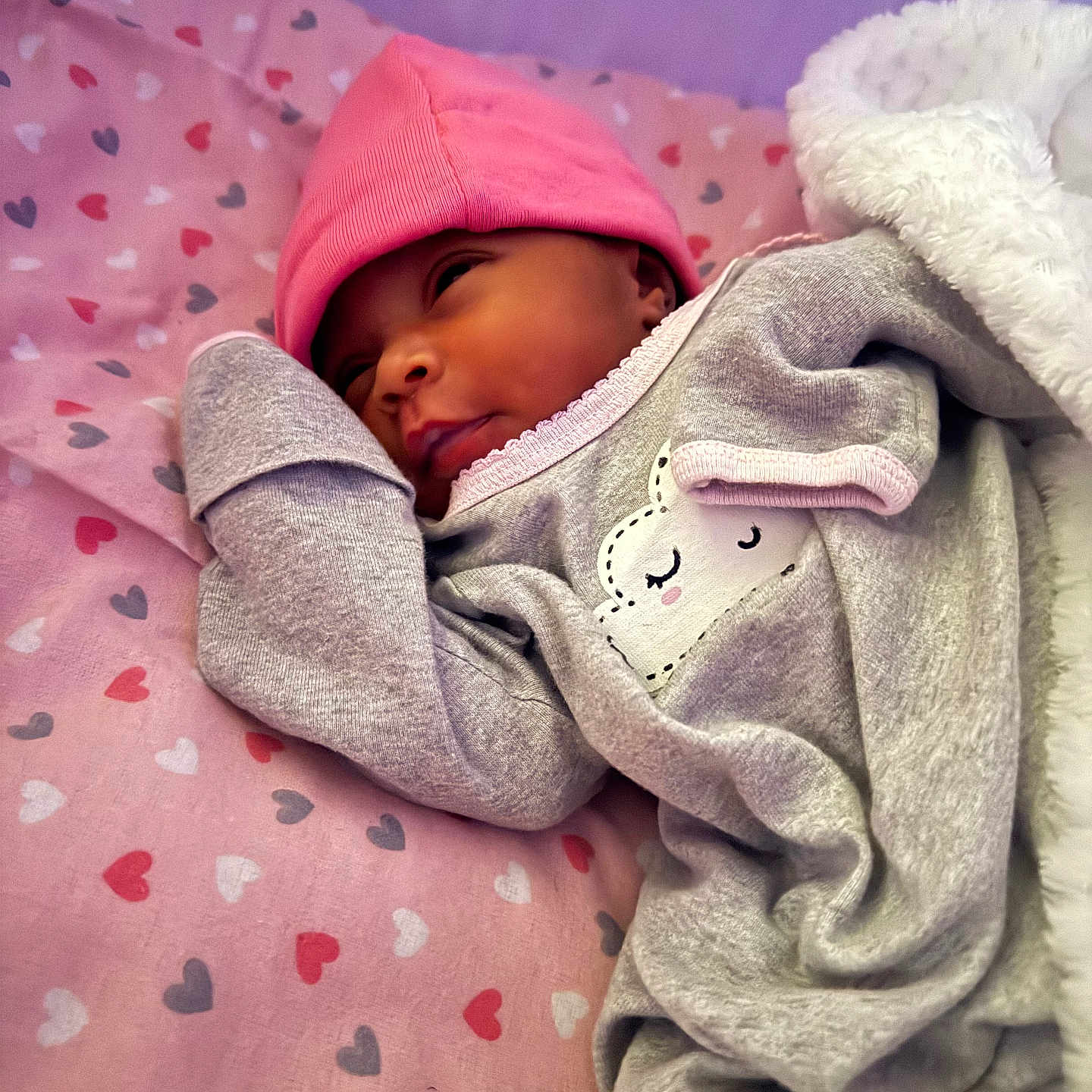 Terriana Marie is registered to the contest to win money with this photo: adorable, baby, bed, blanket, child, cozy, cute, face, grey_outfit, headwear, heart_pattern, infant, lying_down, newborn, pink_hat, resting, sleeping, soft_texture, toddler, warm