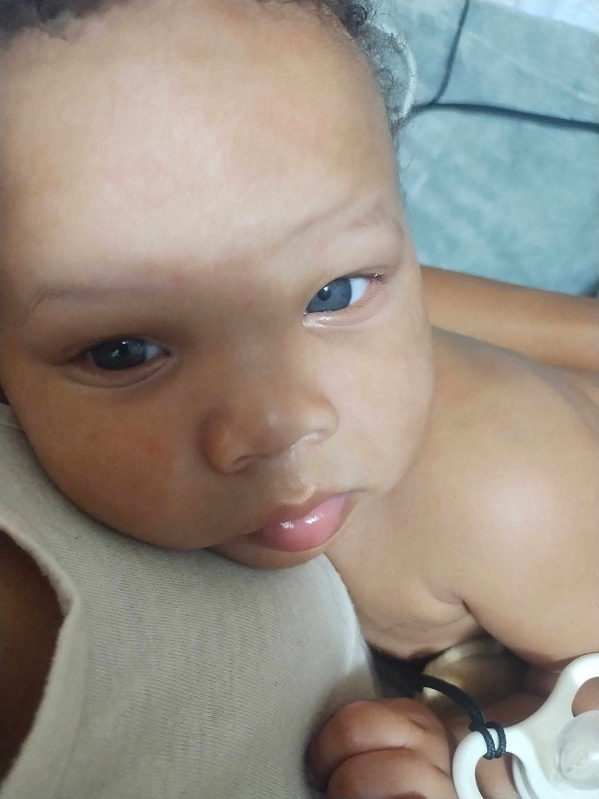 Kdyn is registered to the contest to win money with this photo: baby, close_up, face, blue_eyes, pacifier, hand, skin, child, infant, cute, expression, comfort, resting, portrait, light, fabric, holding, young, indoors, soft