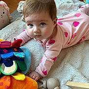 Olivia is registered to the contest to win money with this photo: baby, infant, child, onesie, strawberry_pattern, plush_toy, colorful_toy, mirror, blanket, playmat, tummy_time, closeup, portrait, eyes, hair, hand, wooden_toy, hardwood_floor, indoor, curious_expression