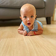Mila joined the competition — help win amazing prizes! baby, bracelet, child, cute, denim_overalls, drool, expression, eyes, face, floor, furniture, head, indoor, infant, mouth, person, skin, sofa, surprised, wooden_floor