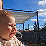 baby, child, smile, laughing, outdoor, blue_sky, clouds, sunlight, backyard, patio, pergola, swing_set, hand, clothing, cheeks, portrait, happy, weekend, play, person