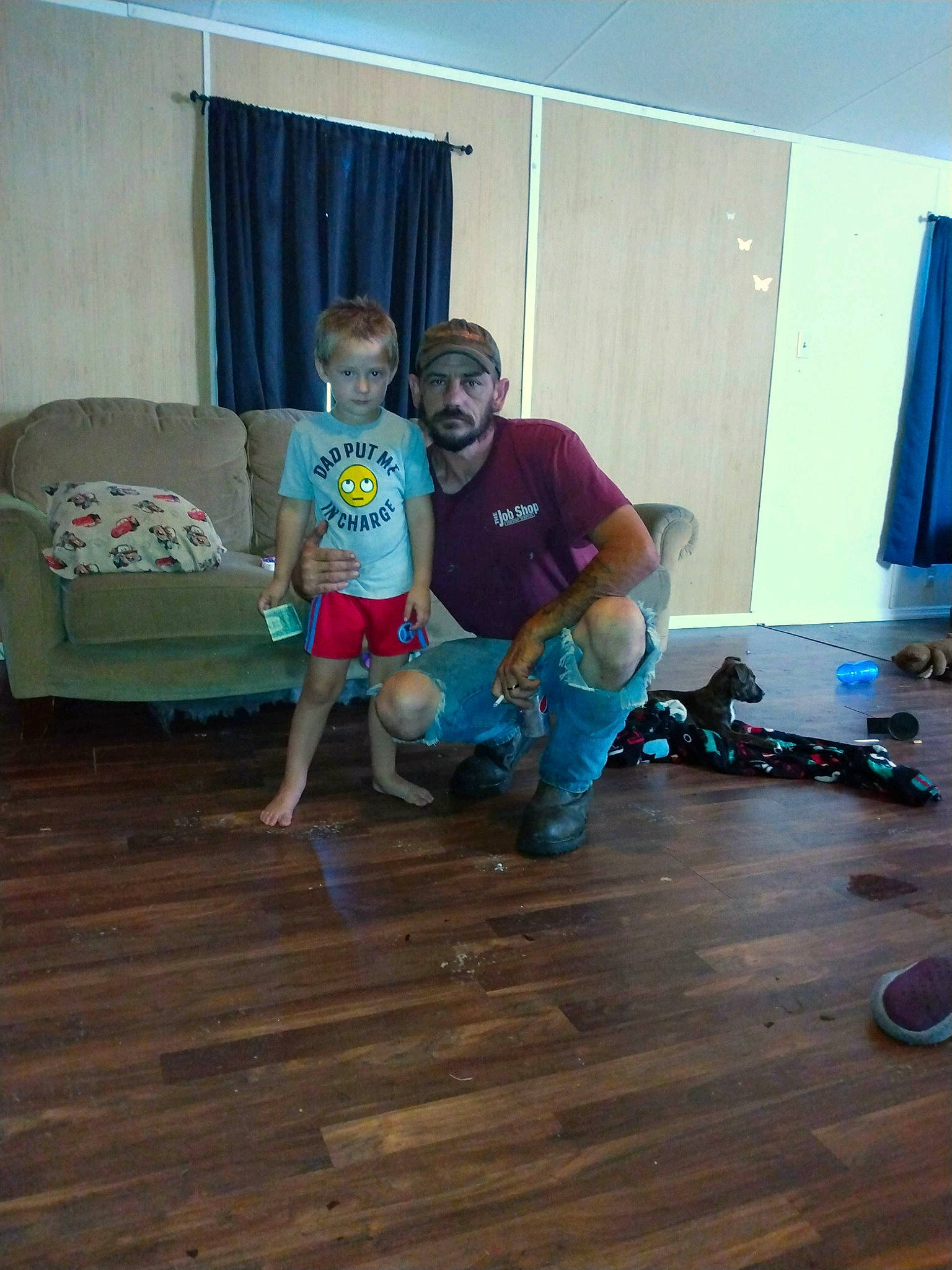 Copper is registered to the contest to win money with this photo: comfort, couch, curtain, event, floor, flooring, fun, hardwood, headwear, laminate_flooring, leisure, living_room, person, room, shorts, sitting, smile, sports_equipment, t_shirt, wood