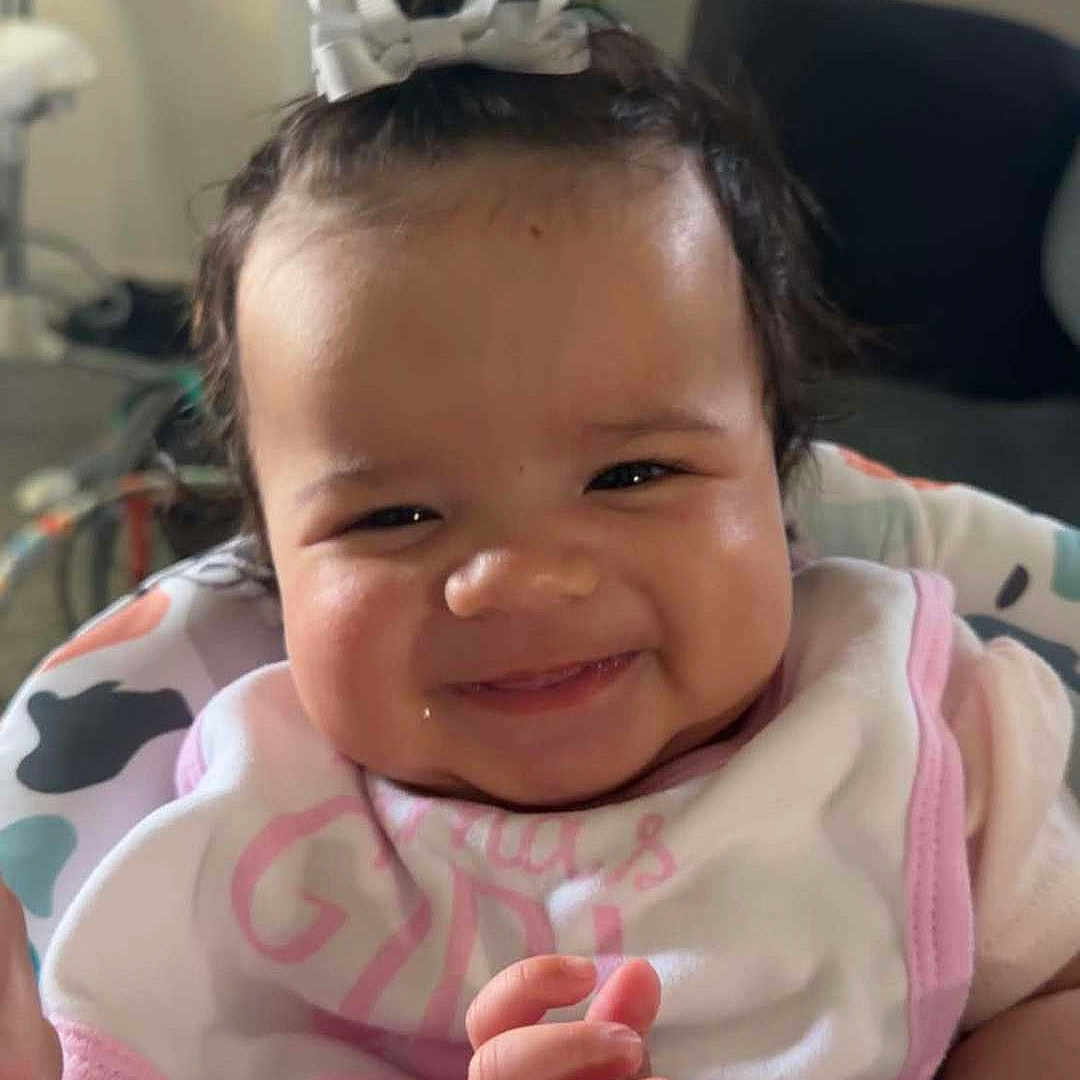 Oaklynn joined the competition — help win amazing prizes! baby, smiling, infant, bow, bib, child, cute, happy, face, hands, indoor, seat, colorful, person, portrait, clothing, baby_girl, expression, young, joyful