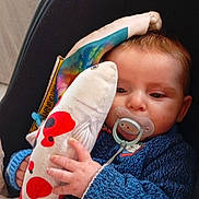 Naël a rejoint le concours — aidez-le/la à gagner de superbes lots ! baby, blanket, blue_sweater, car_seat, child, closeup, comfort, cute, face, hand, indoors, infant, knitwear, pacifier, plush_toy, resting, sleepy, soft_texture, toy, warm