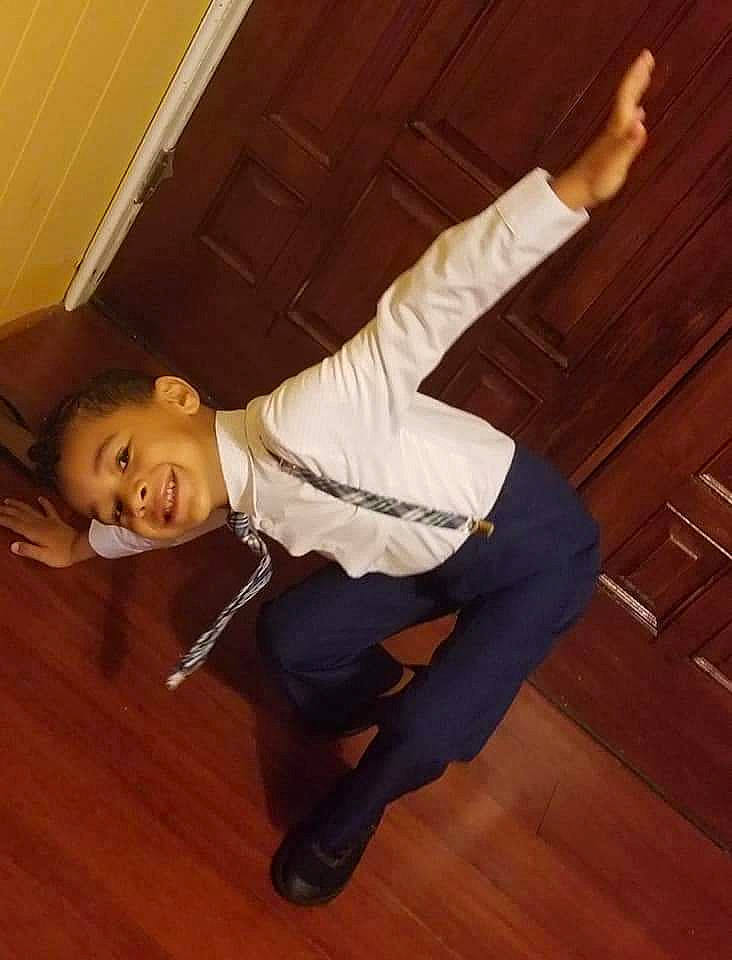 Landon is registered to the contest to win money with this photo: brown, dress_shirt, event, flash_photography, floor, flooring, happy, hardwood, human_leg, joy, knee, laminate_flooring, person, shoe, sitting, smile, sportswear, thigh, varnish, wood