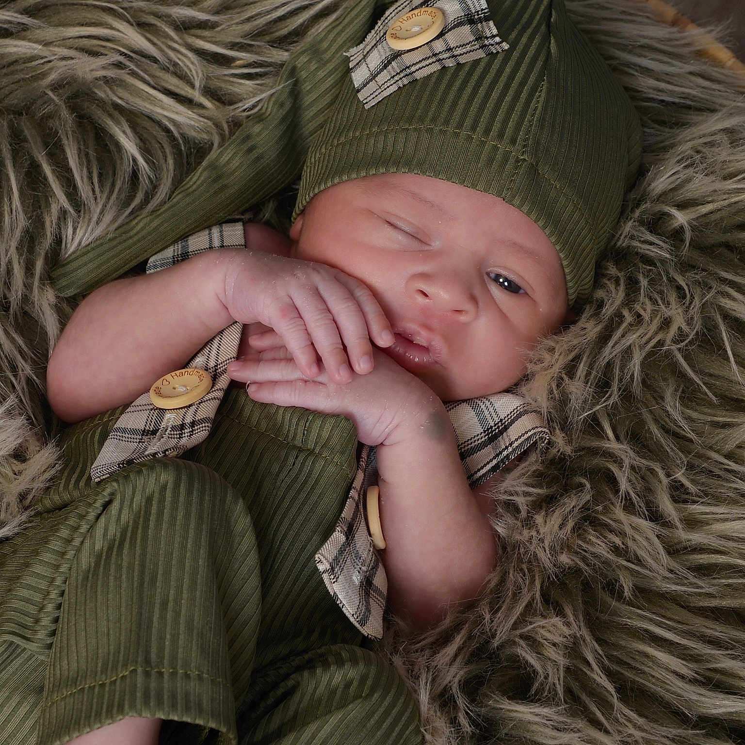 Dallas joined the competition — help win amazing prizes! baby, button, child, closeup, cozy, cute, fur_blanket, green_outfit, hat, indoors, infant, newborn, one_eye_open, plaid_pattern, portrait, resting, sleepy, small_feet, small_hands, soft_texture