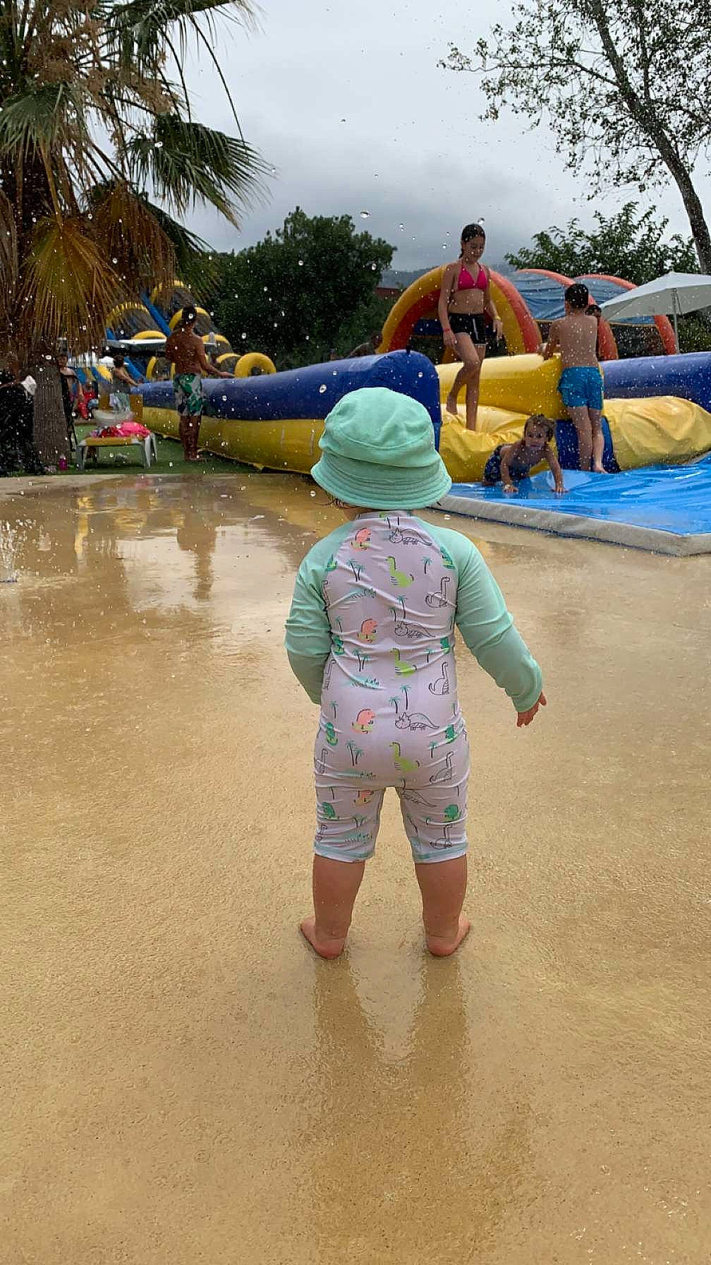 Lya a rejoint le concours — aidez-le/la à gagner de superbes lots ! arecales, barefoot, child, chute, cloud, fun, hat, leisure, nonbuilding_structure, outdoor_play_equipment, palm_tree, person, play, playground, recreation, sand, shade, sky, toddler, tree