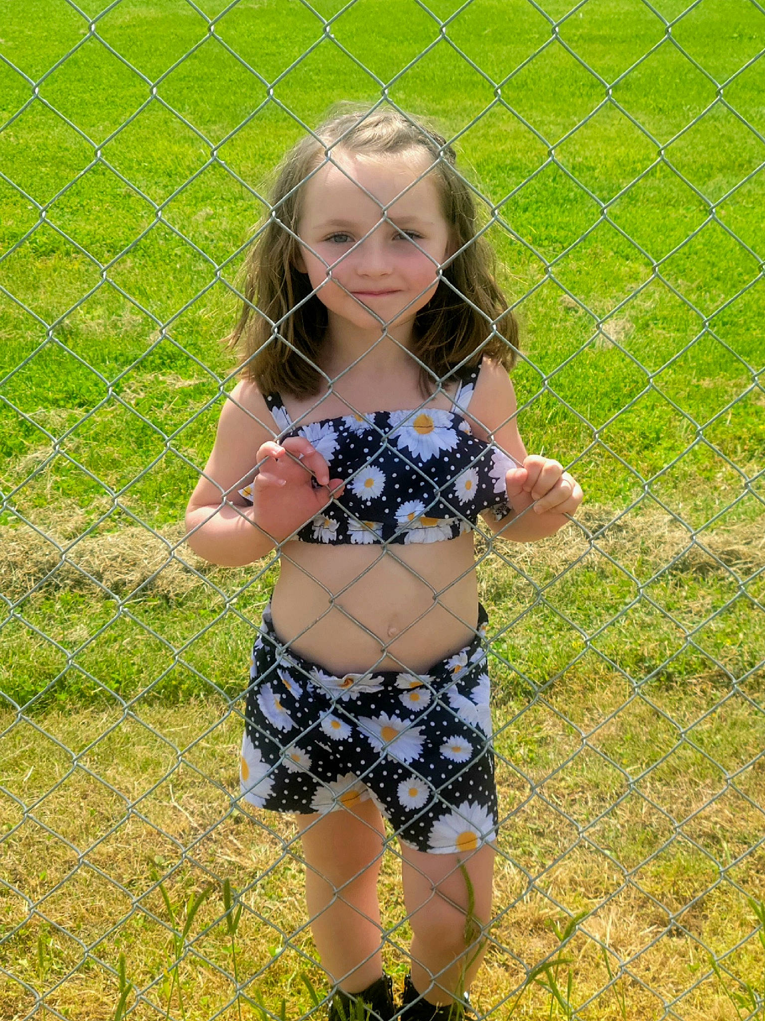 Riley is registered to the contest to win money with this photo: baby_toddler_clothing, eye, face, fawn, fence, grass, hair, happy, head, leaf, meadow, mesh, nature, people_in_nature, person, plant, shorts, smile, toddler, waist
