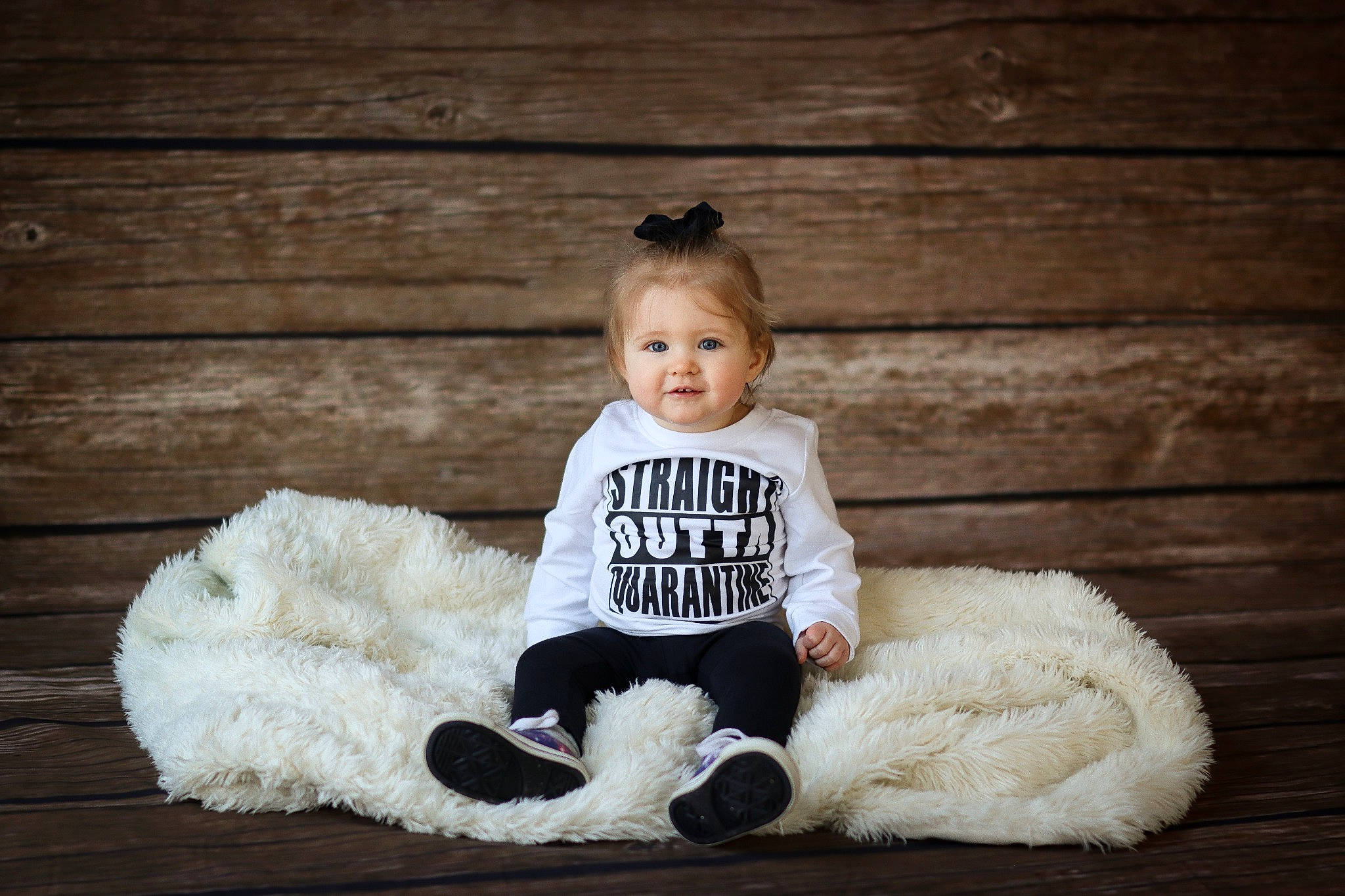 Gracelyn joined the competition — help win amazing prizes! baby, baby_toddler_clothing, child, face, flash_photography, flooring, fur, fur_clothing, happy, hardwood, mammal, monochrome, person, sitting, sleeve, smile, sunglasses, toddler, white, wood