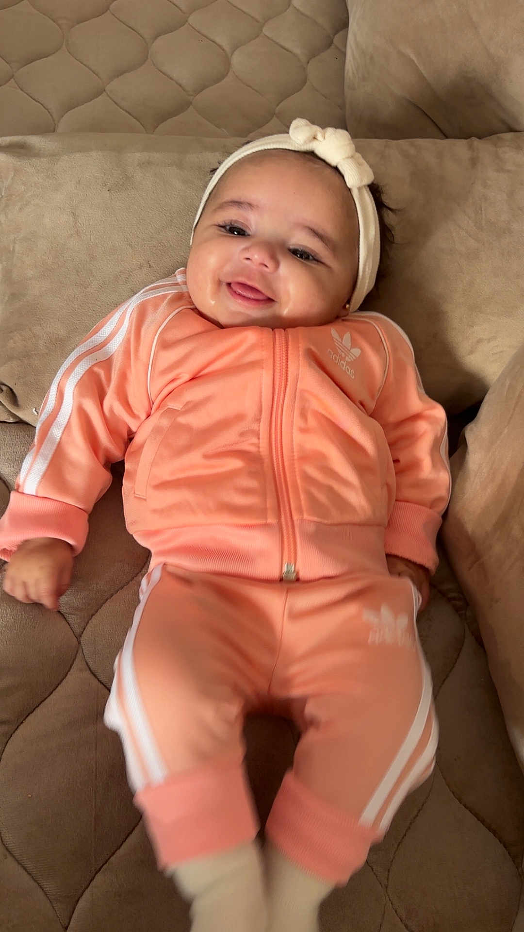 Anya participe au concours pour gagner de l'argent avec cette photo : baby, child, smiling, headband, couch, tracksuit, adidas, clothing, infant, happy, portrait, indoors, cute, sitting, soft_furniture, person, fashion, cozy, young_child, comfortable