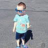 child, boy, sunglasses, tshirt, dinosaur, lollipop, shorts, shoes, outdoor, sunny, shadow, asphalt, standing, casual, cute, fashion, summer, happy, kid, playground