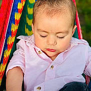 Adrián is registered to the contest to win money with this photo: baby, child, infant, sleeping, hammock, colorful, pink_shirt, outdoor, relaxing, peaceful, portrait, close_up, casual_clothing, bracelet, nature, daylight, soft_lighting, young_child, resting, calm