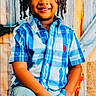 child, boy, smiling, braided_hair, blue_shirt, jeans, autumn_leaves, pumpkin, rustic_background, fall, festive, portrait, posing, happy, indoors, colorful, casual_clothing, cute, seasonal, decoration
