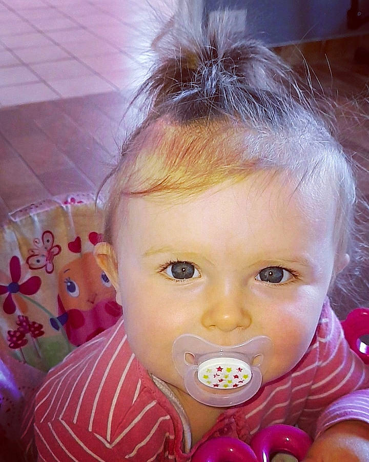 Mila participe au concours pour gagner de l'argent avec cette photo : baby, brown_hair, cheek, child, ear, eye, face, forehead, fun, hair, head, iris, lip, mouth, nose, person, pink, skin, toddler