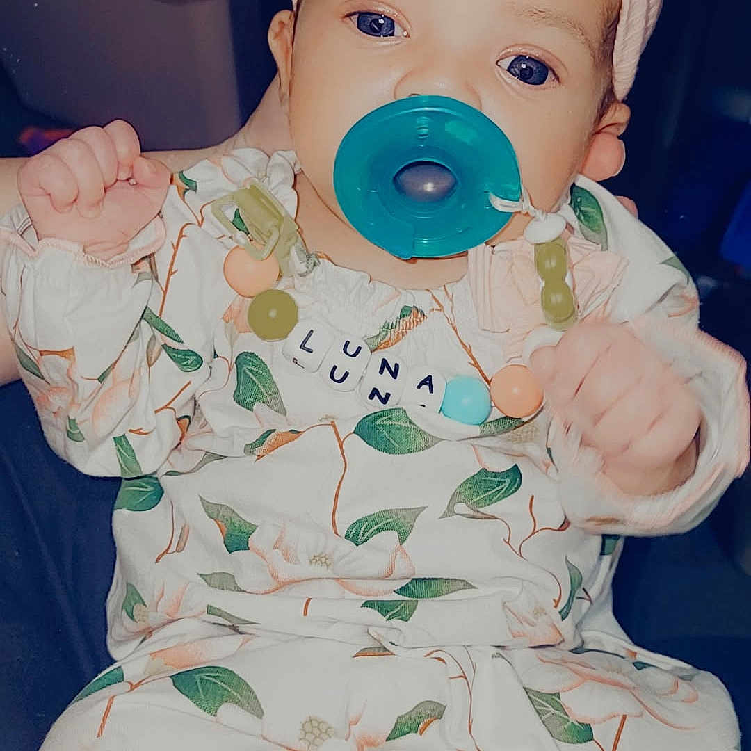 Luna is registered to the contest to win money with this photo: baby, biting, cap, clothing, face, happy, hat, head, person, photography, portrait, sitting, sleeve