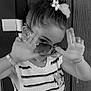 Melya a rejoint le concours — aidez-le/la à gagner de superbes lots ! child, girl, sunglasses, striped_top, minnie_mouse, flower_hair_accessory, hair_bun, bracelet, playful_pose, black_and_white, portrait, indoor, wooden_door, fashion, cute, young, accessory, hand_gesture, casual, smile