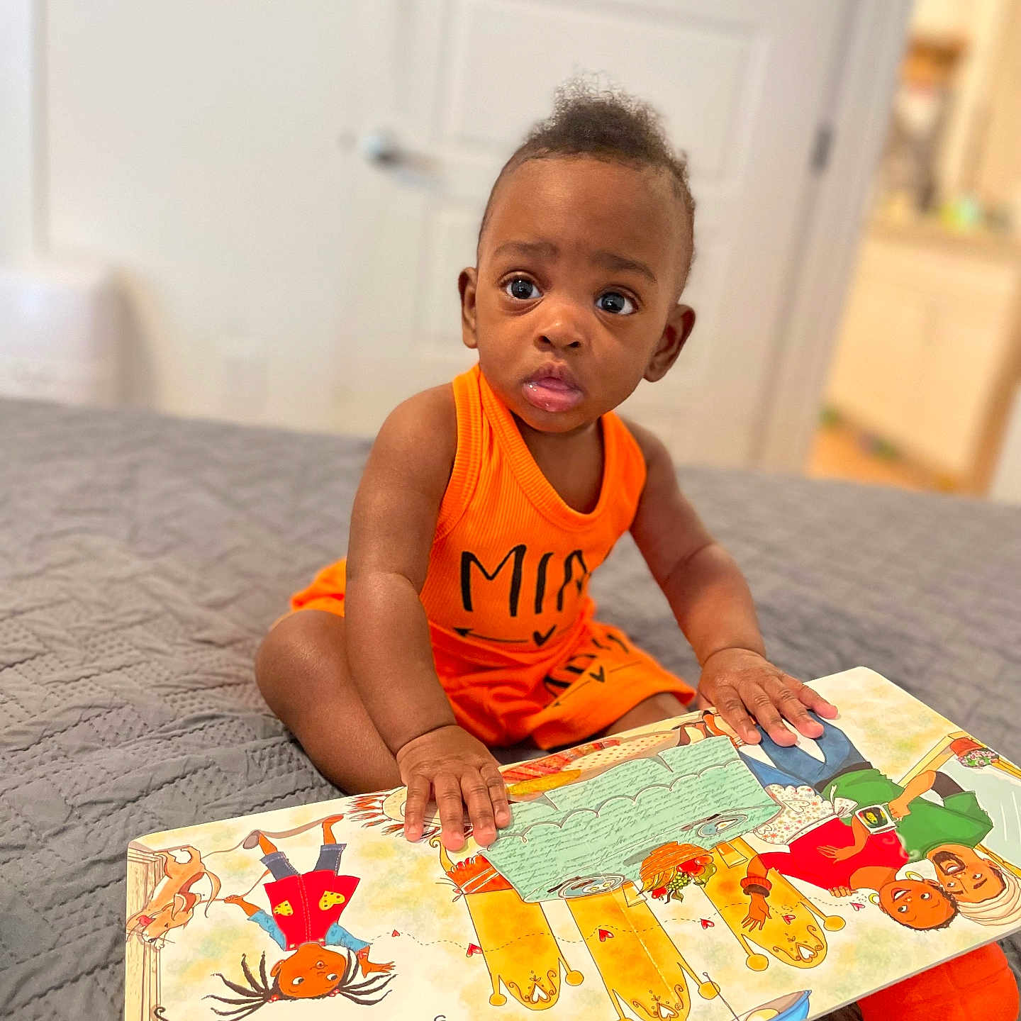 Ruby is registered to the contest to win money with this photo: baby, bodypart, clothing, crawling, face, finger, hand, head, number, person, photography, play, portrait, quilt, reading, sitting, sleeve, student, symbol, text