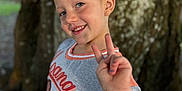 Avery joined the competition — help win amazing prizes! child, girl, smile, peace_sign, bow, hair_accessory, tree, outdoor, nature, casual_clothing, freckles, portrait, happy, young, person, hand_gesture, daylight, background_blur, closeup, cute