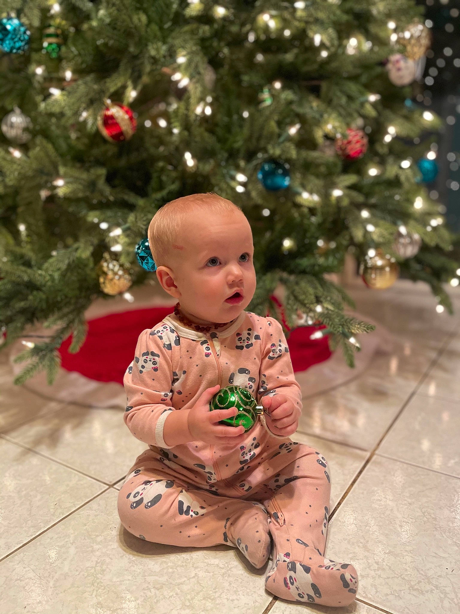 Avery joined the competition — help win amazing prizes! baby, baby_toddler_clothing, cheek, christmas, christmas_decoration, christmas_eve, christmas_lights, christmas_ornament, christmas_tree, doll, event, figurine, holiday, holiday_ornament, human, interior_design, ornament, person, sitting, surprise