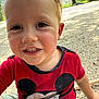 casual_clothing, child, closeup, cute, daylight, face, gravel, greenery, happy, mickey_mouse, nature, outdoor, person, playful, red_shirt, smiling, summer, toddler, trees, young_child