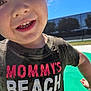 child, smiling, close_up, face, wet, tshirt, outdoor, daylight, sunshine, blue_sky, playful, happy, young_child, teeth, casual_clothing, person, summer, fun, cute, portrait