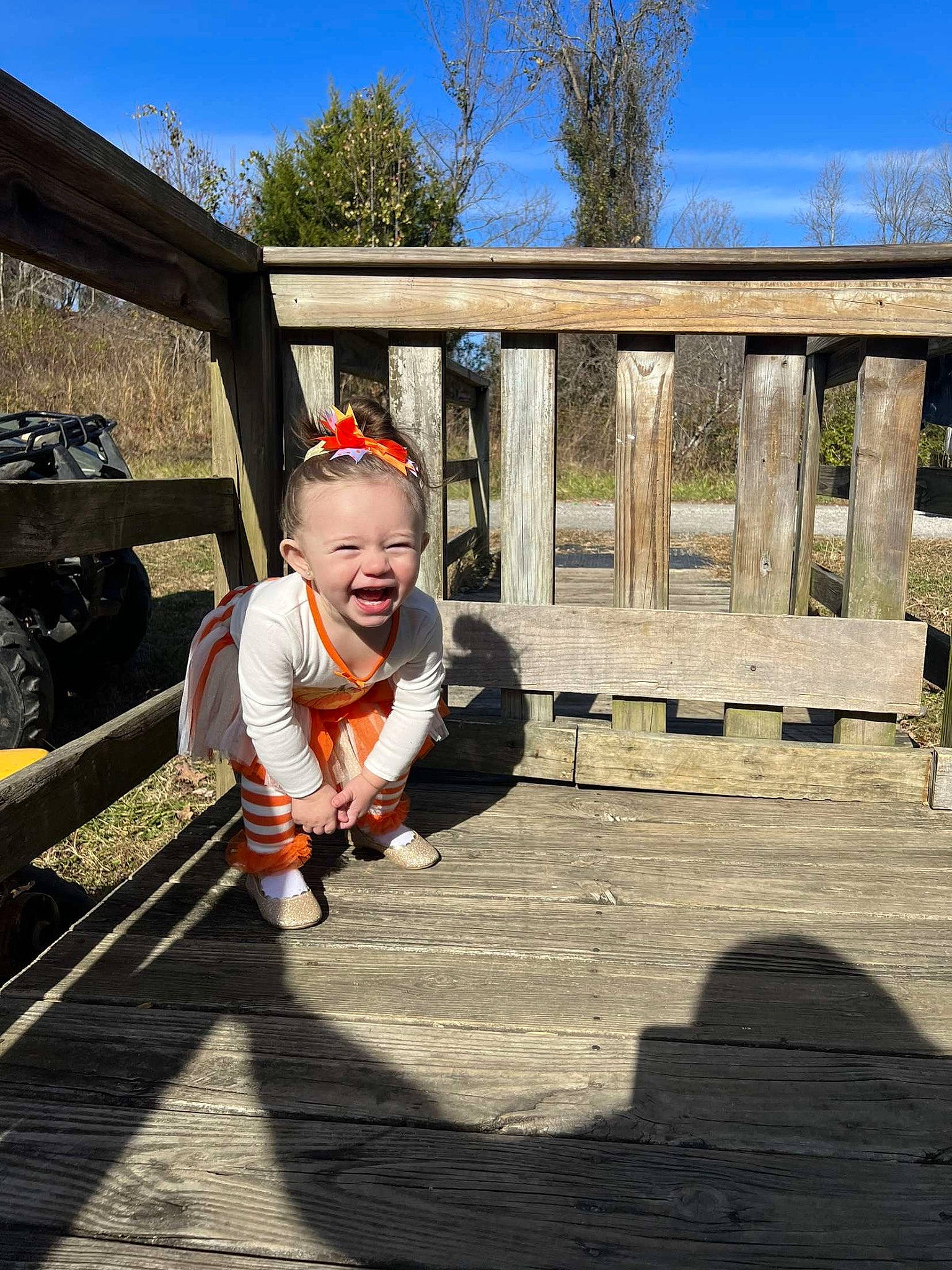 Oakley is registered to the contest to win money with this photo: asphalt, bridge, child, flooring, fun, grass, landscape, leisure, person, recreation, road_surface, sitting, sky, toddler, track, travel, tree, vacation, walkway, winter